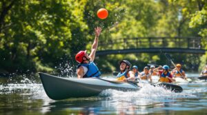 Athletes playing canoe polo on a sunny canal, splashing water as they compete for the ball, with green trees and a wooden footbridge in the blurred background.